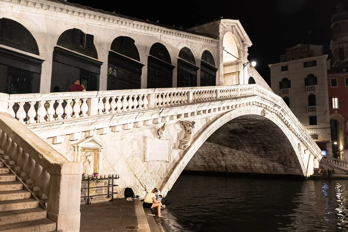 The stone arch and balustrade of the Rialto Bridge at night